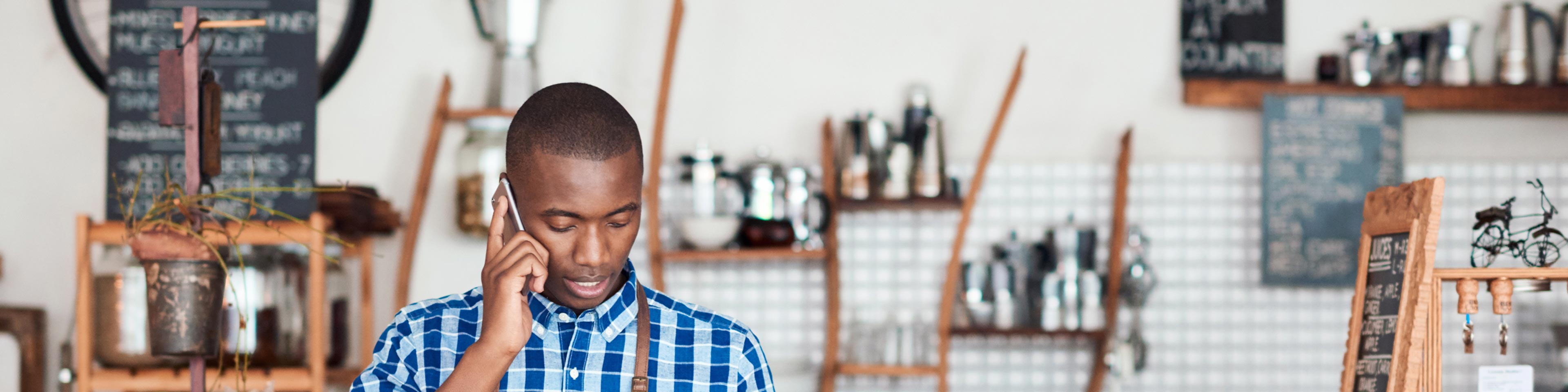 small business owner completing new employee forms while talking on phone