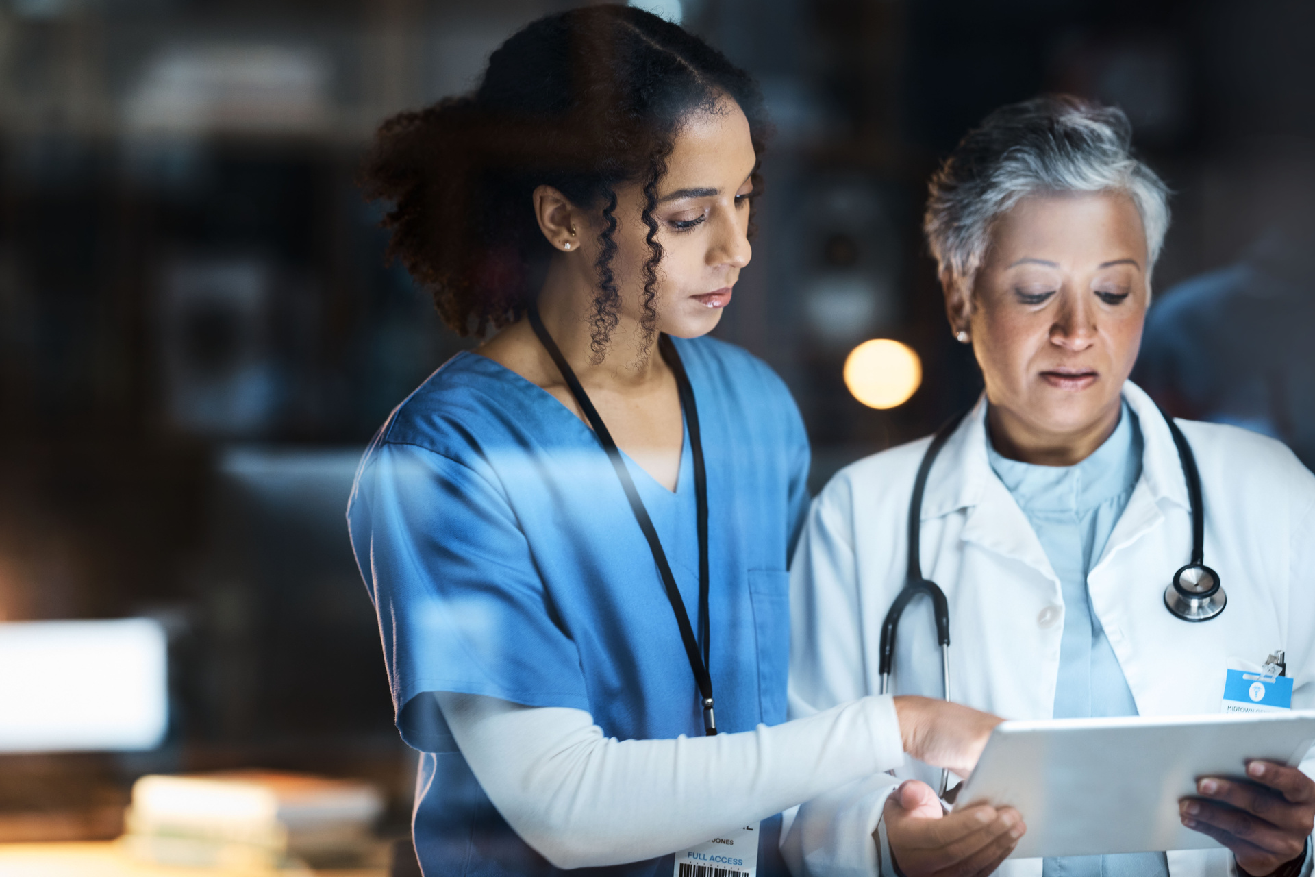 Two clinicians looking at tablet