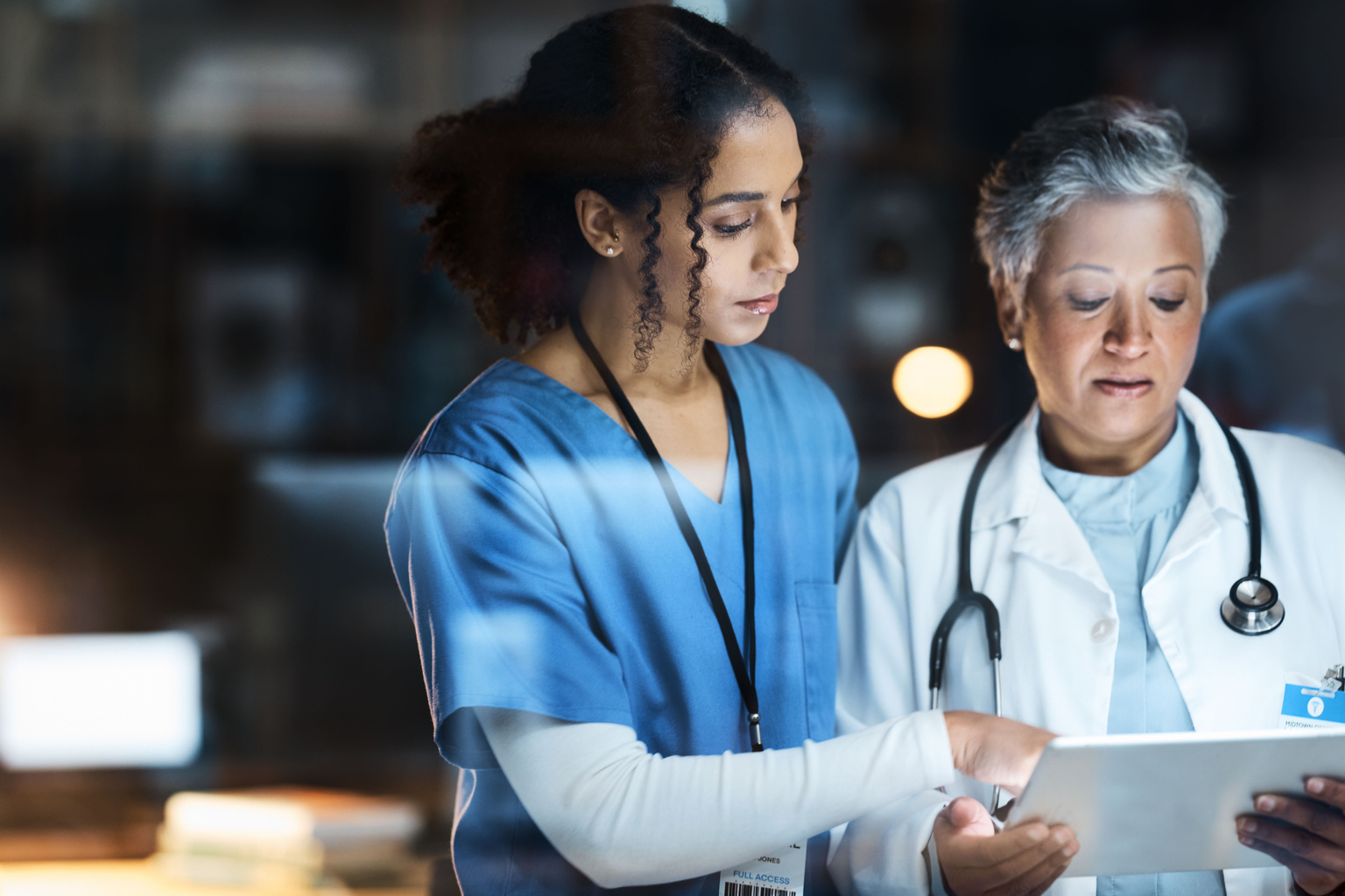 Two clinicians looking at tablet