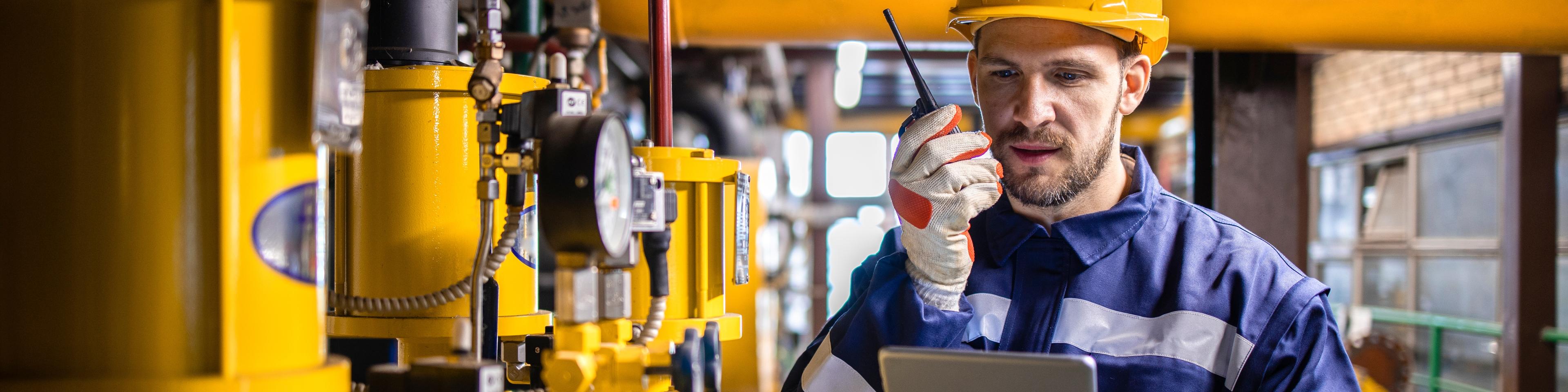 Refinery engineer standing by natural gas pipeline and controlling storage capacity of LNG terminal.