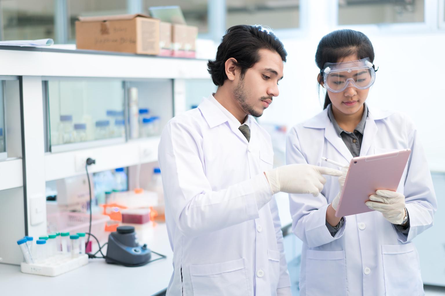 Two lab workers looking at tablet