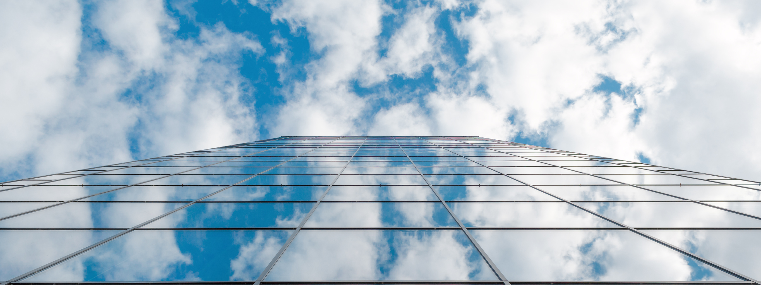 modern business high rise glass building and blue sky with clouds 