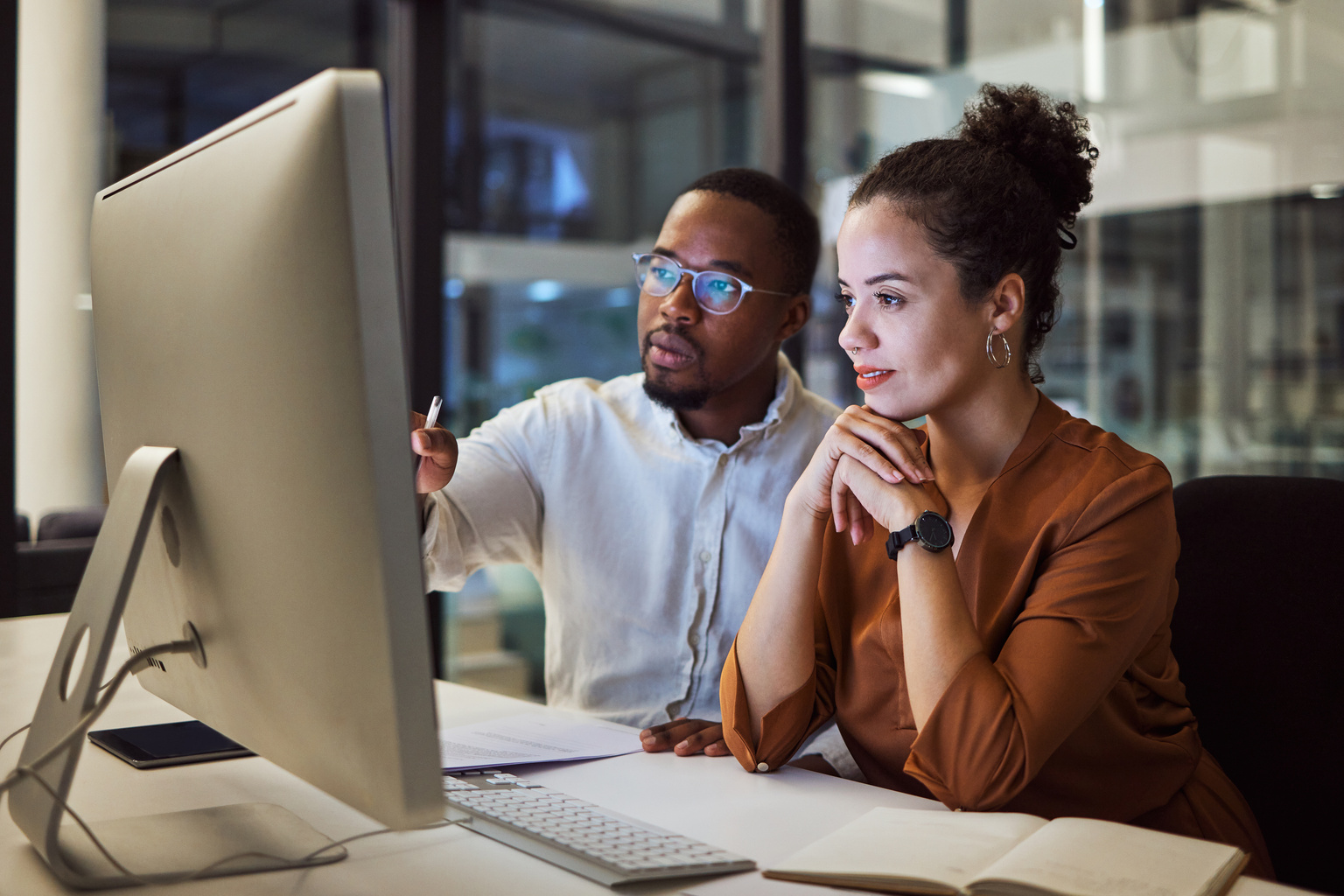 Two business people looking at computer monitor