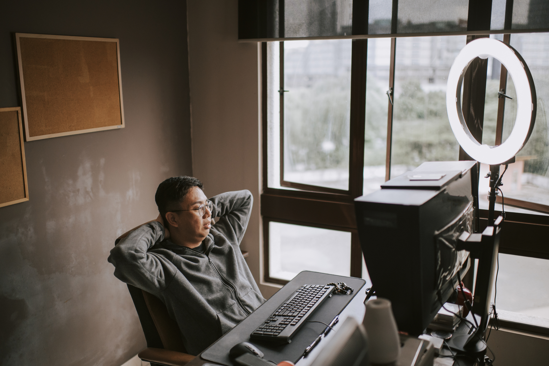 A man using ring light with his desktop in his office room at home