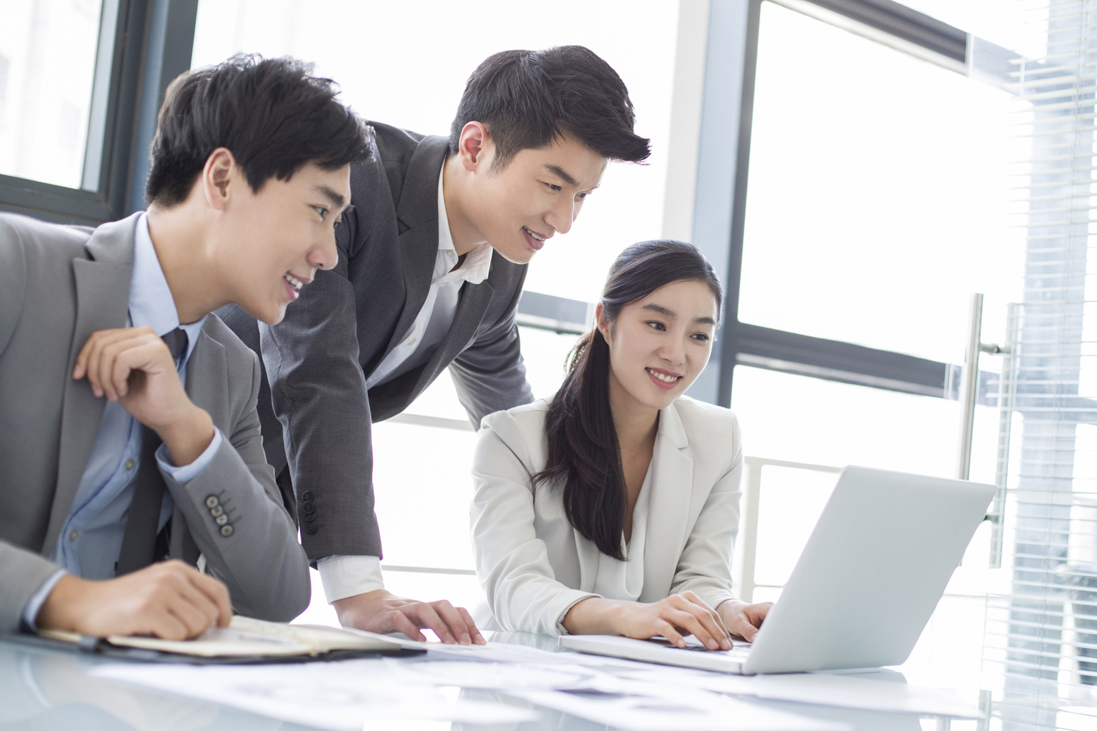 Young Asian business people in meeting working together on laptop
