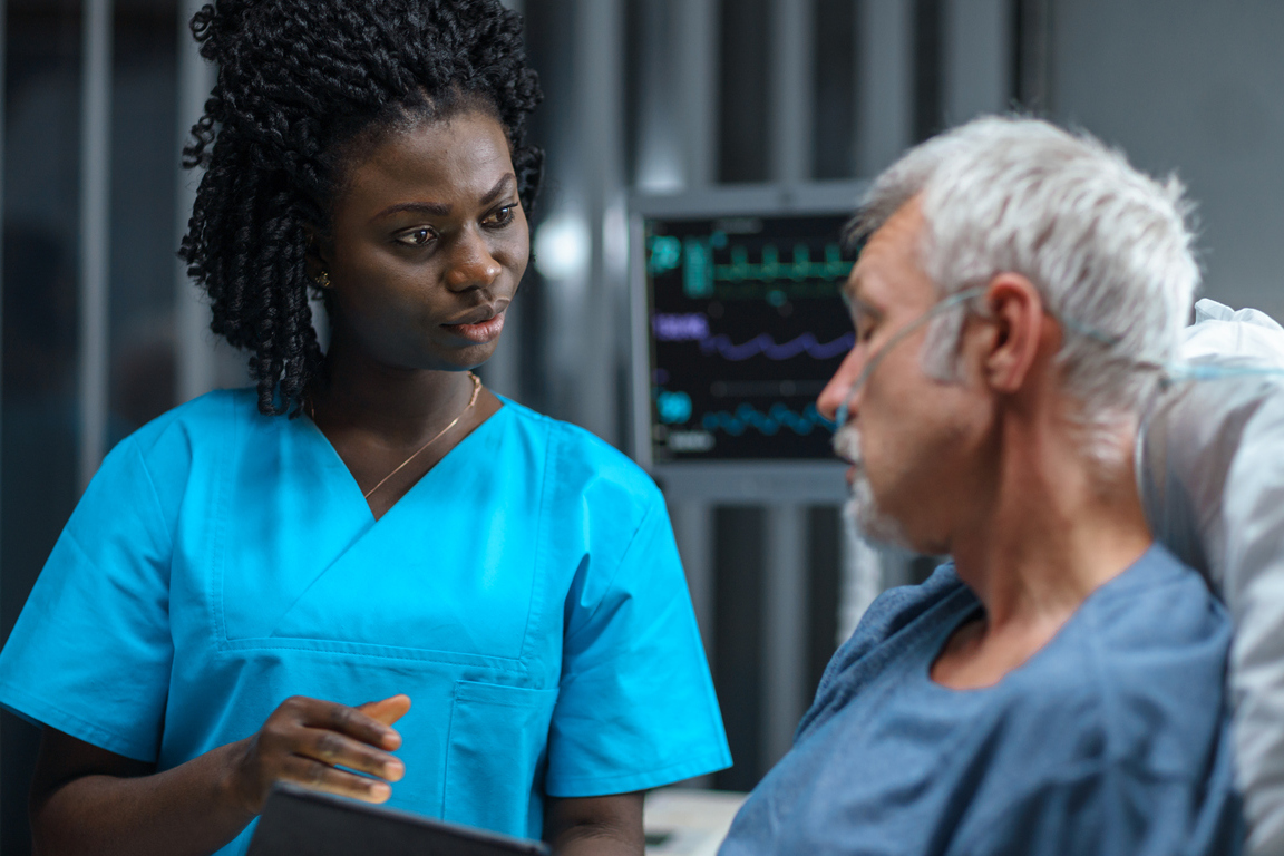 A nurse speaking to a patient lying in bed after using practice nursing case studies in Lippincott Client Cases to develop Clinical Judgment to pass the Next-Gen NCLEX exam.