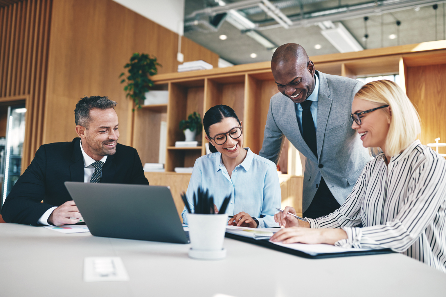 Diverse group of businesspeople laughing together during an office meeting