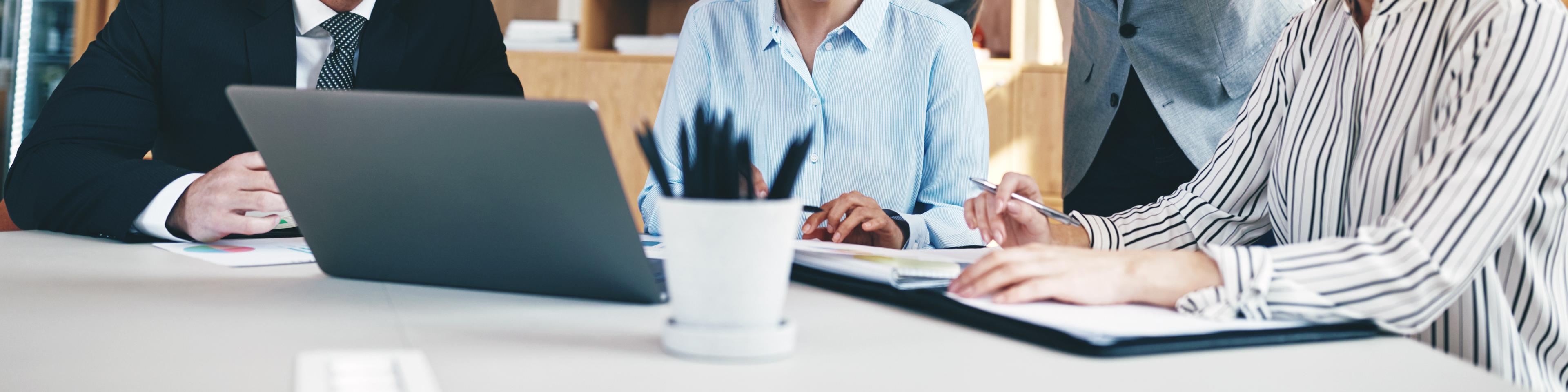 Diverse group of businesspeople laughing together during an office meeting