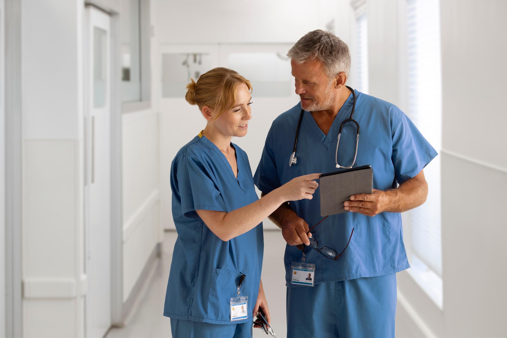 Doctor stops nurse in hallway to ask about patient records referenced on a tablet