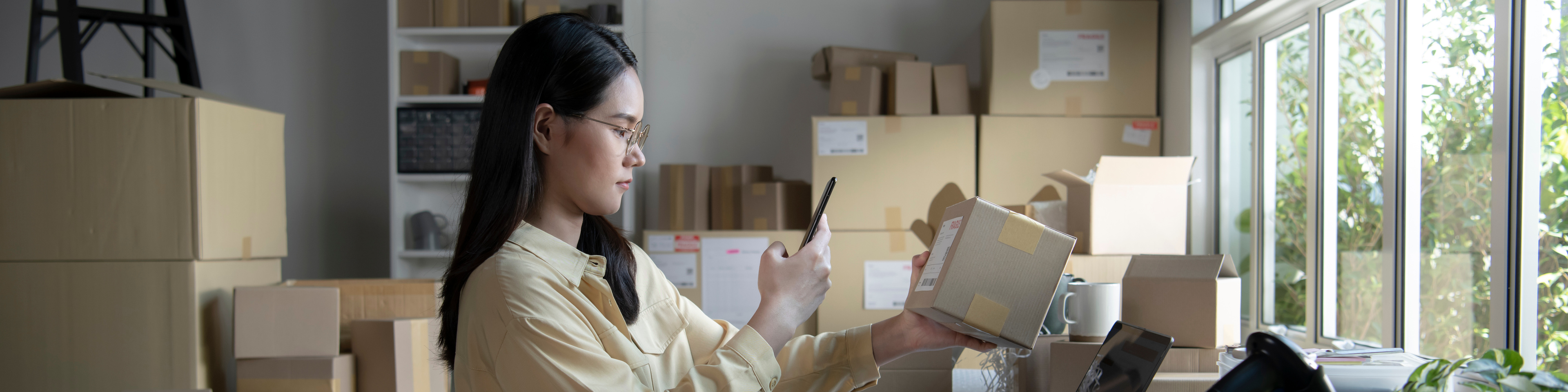 Small business owner using mobile app on smartphone checking parcel box