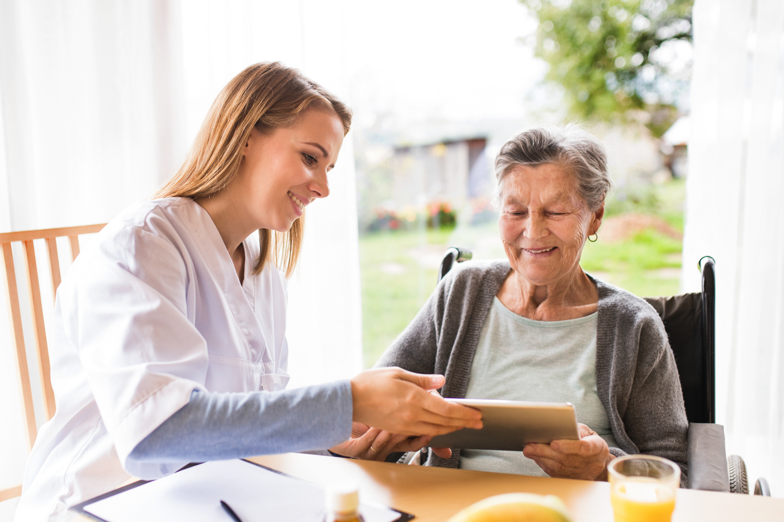 Health visitor and a senior woman with tablet.