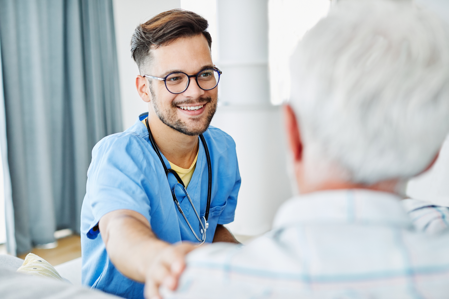 Medical professional providing assistance to elderly man in nursing home 