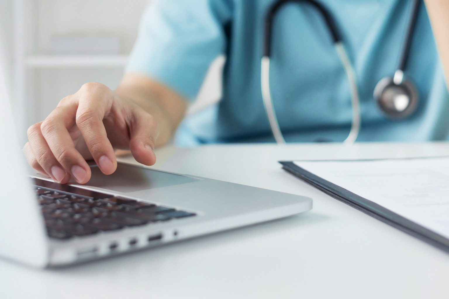 Doctor or nurse in blue uniform concentrate working on laptop computer in hospital