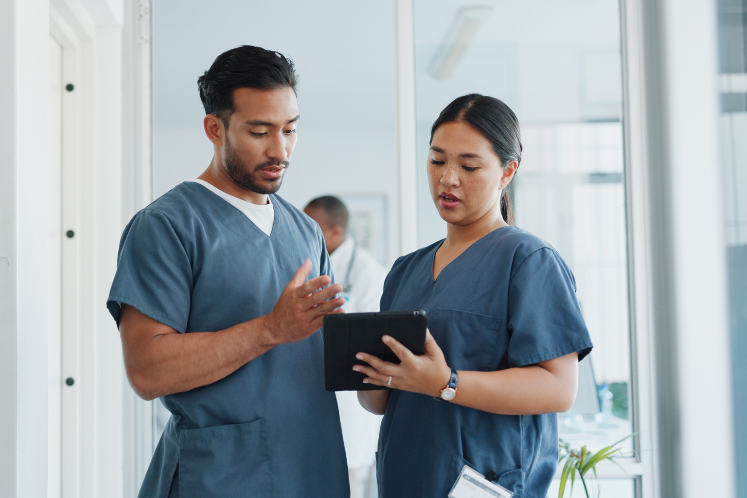 Group two, male and female nurse communicating, planning, collaborating, discussing with a tablet AS566595863