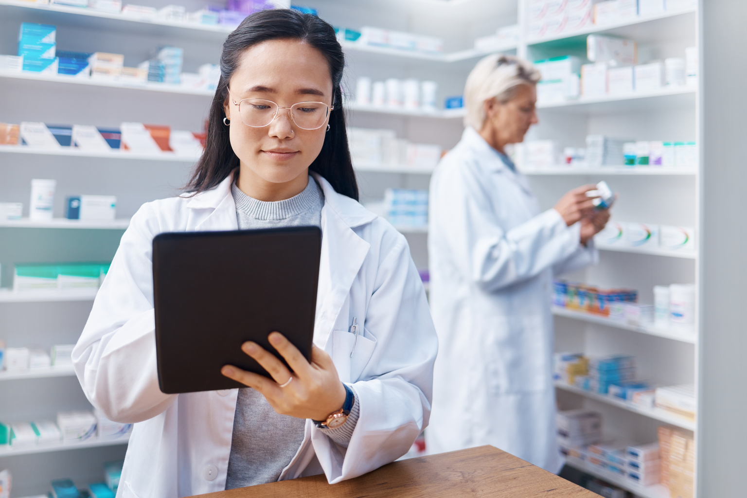 Medication, telehealth technology and female medical doctor with touchscreen for research in shop.