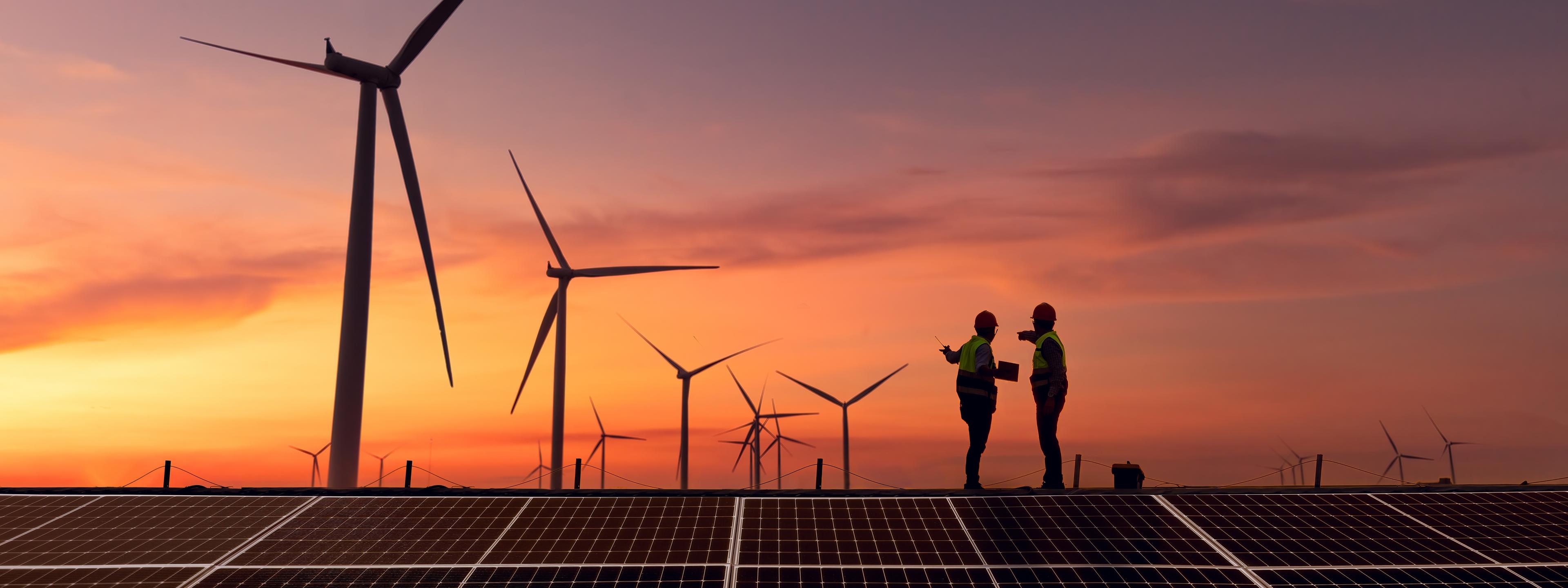 Silhouette engineer working on solar cell plant with windmill field .Solar cell smart grid and windmill are ecology energy renewable sunlight alternative green power environment factory concept