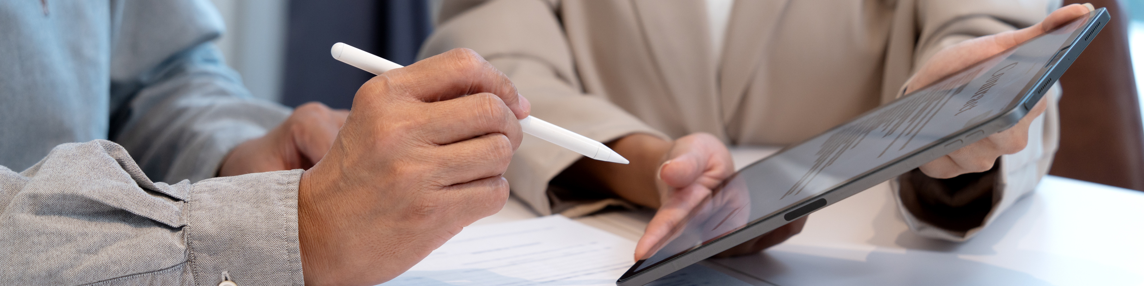 Woman handing an electronic document on a tablet for a businessman to sign