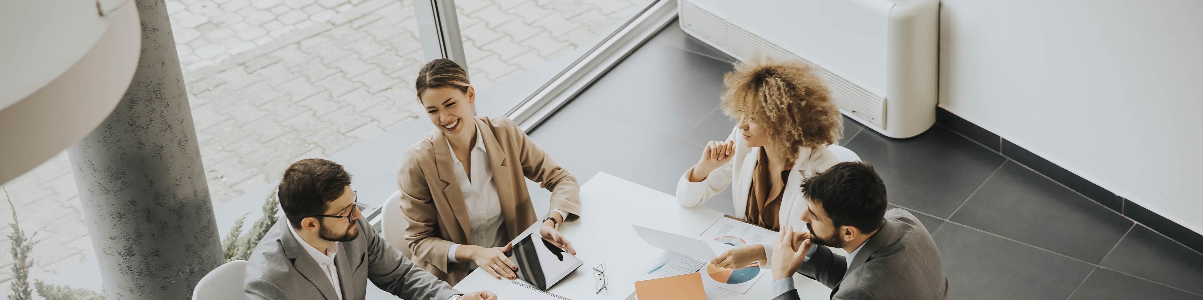 4 businesspeople sitting around a table having a discussion