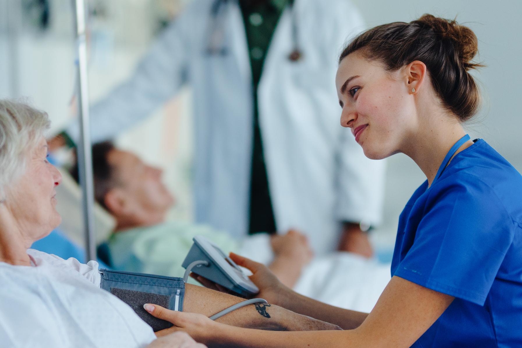 Nurse taking patient's blood pressure at bedside