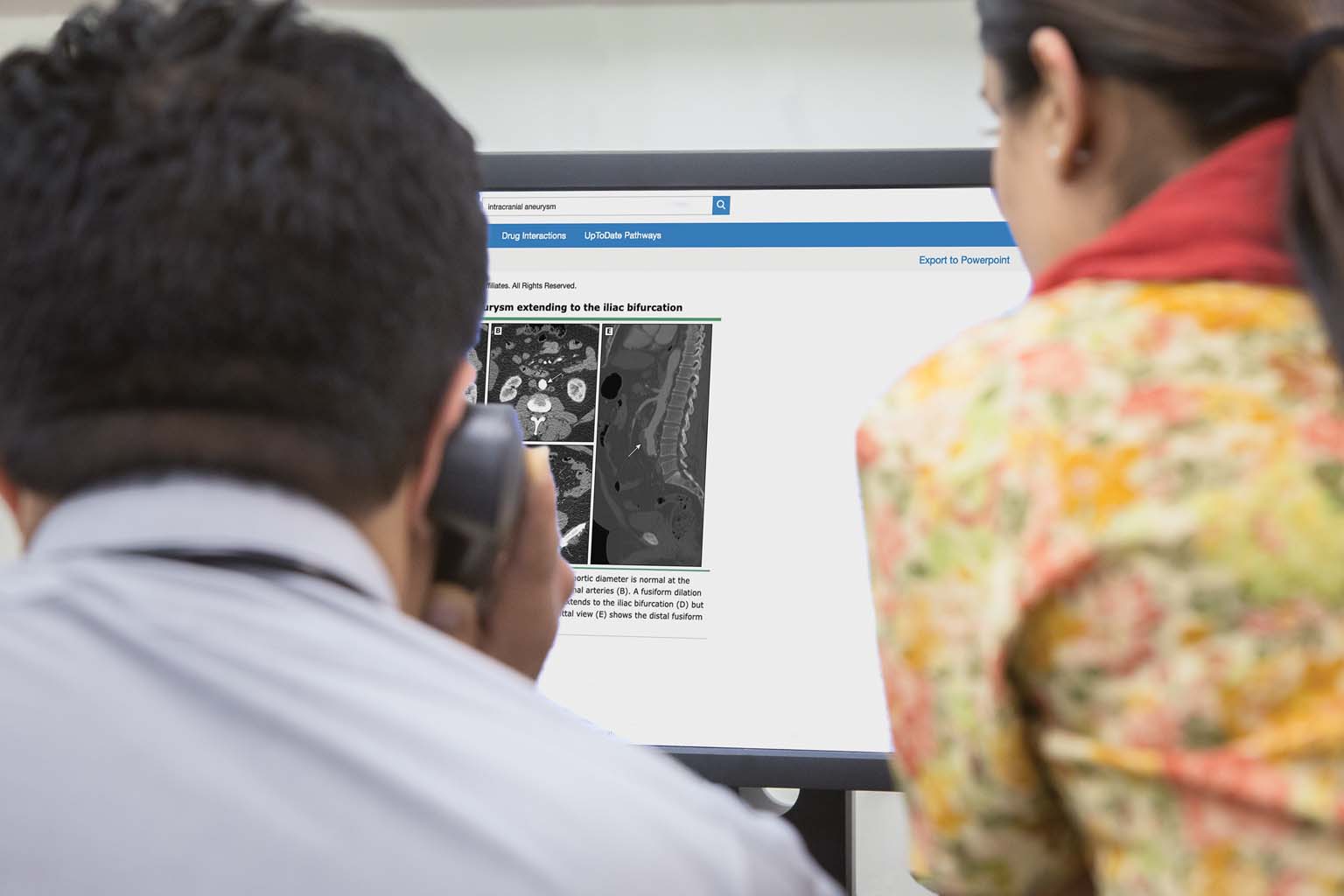 two doctors looking at computer displaying UpToDate