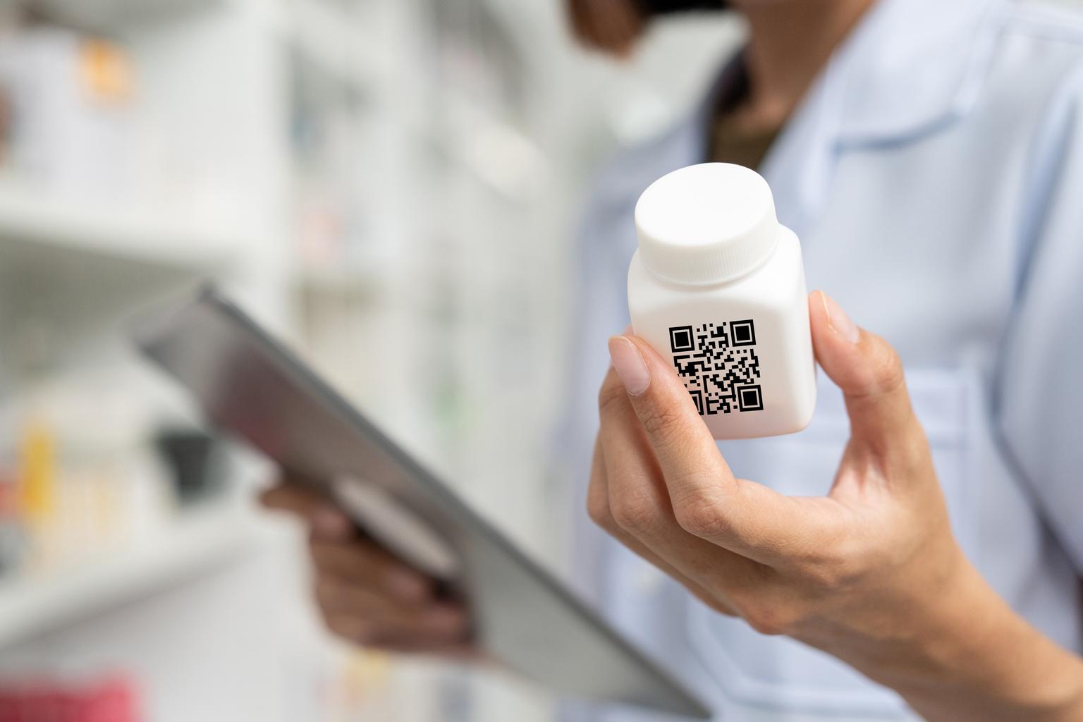 Close-up of woman's hands holding a medicine bottle near drug shelves