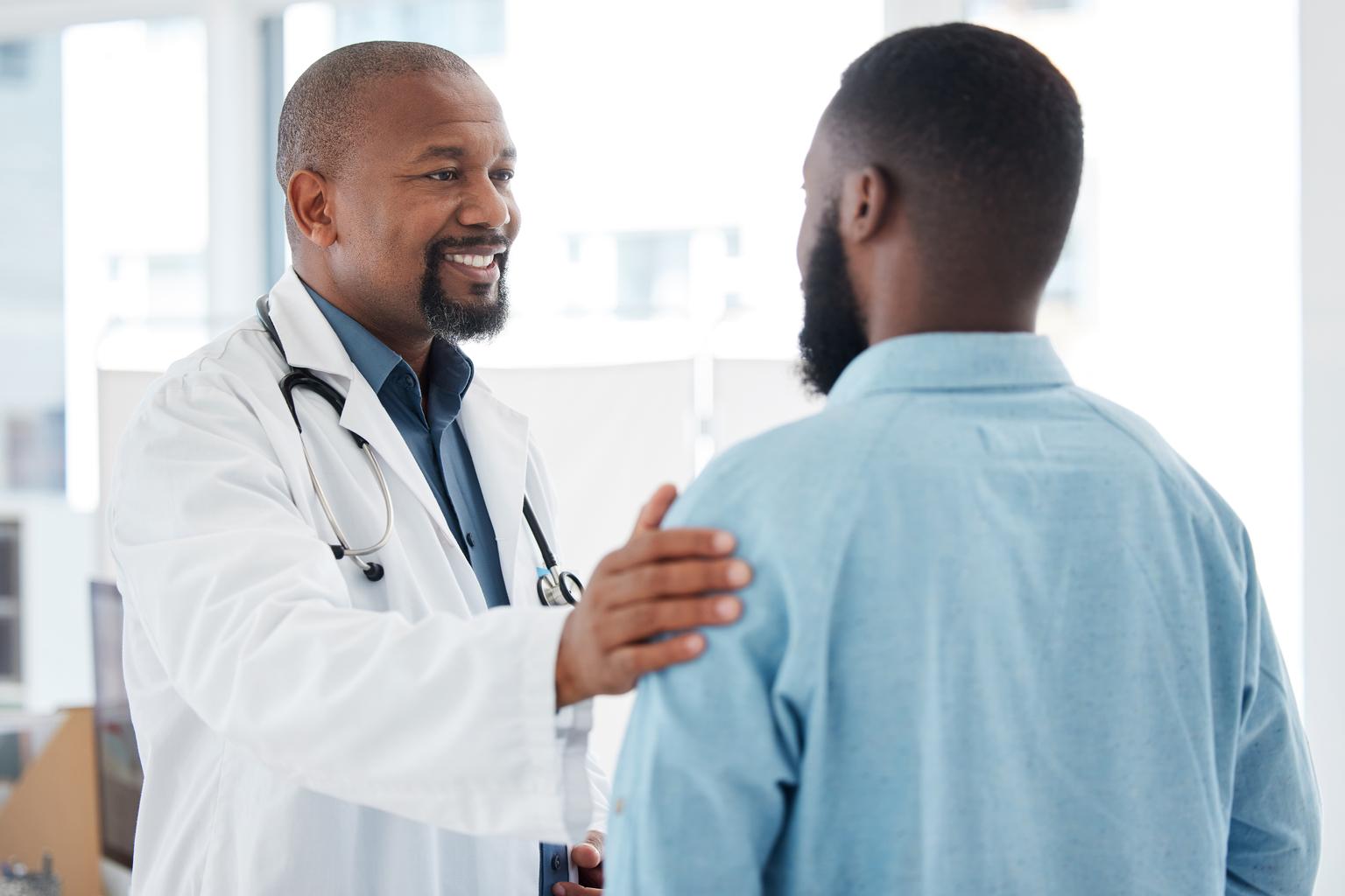 A doctor touching the shoulder of a patient in support