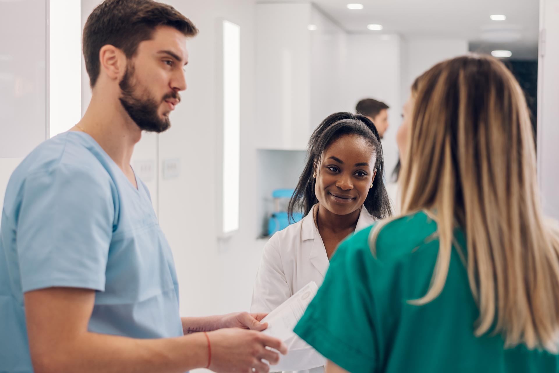 Group of medical professionals chat informally in hospital hallway