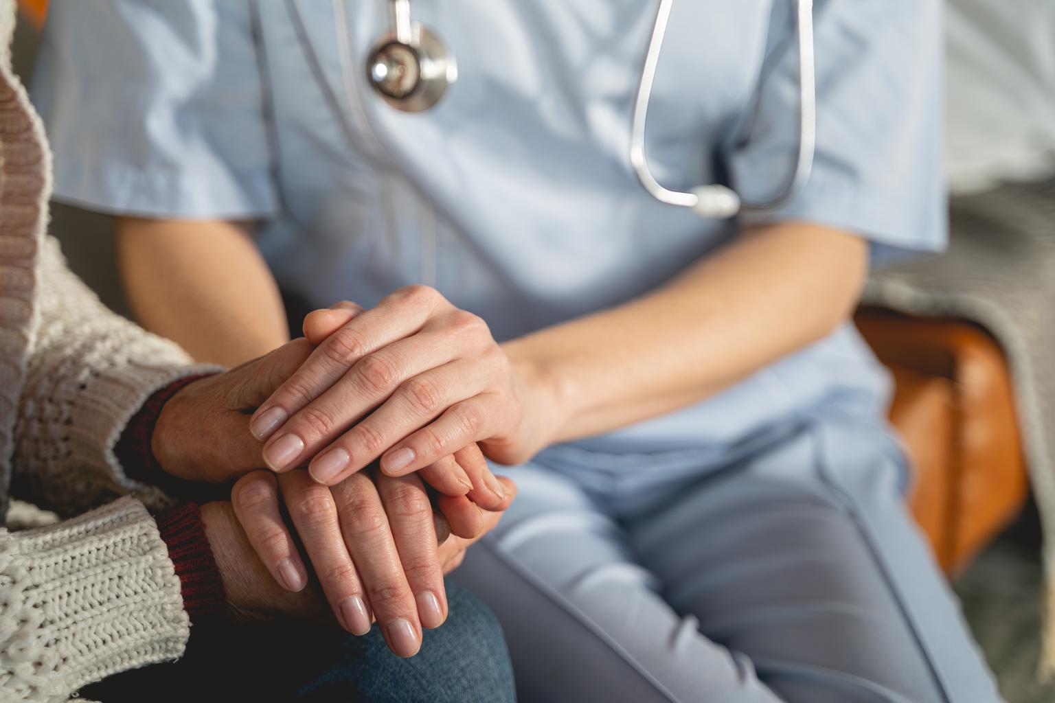 Close up of young doctor sitting near patient