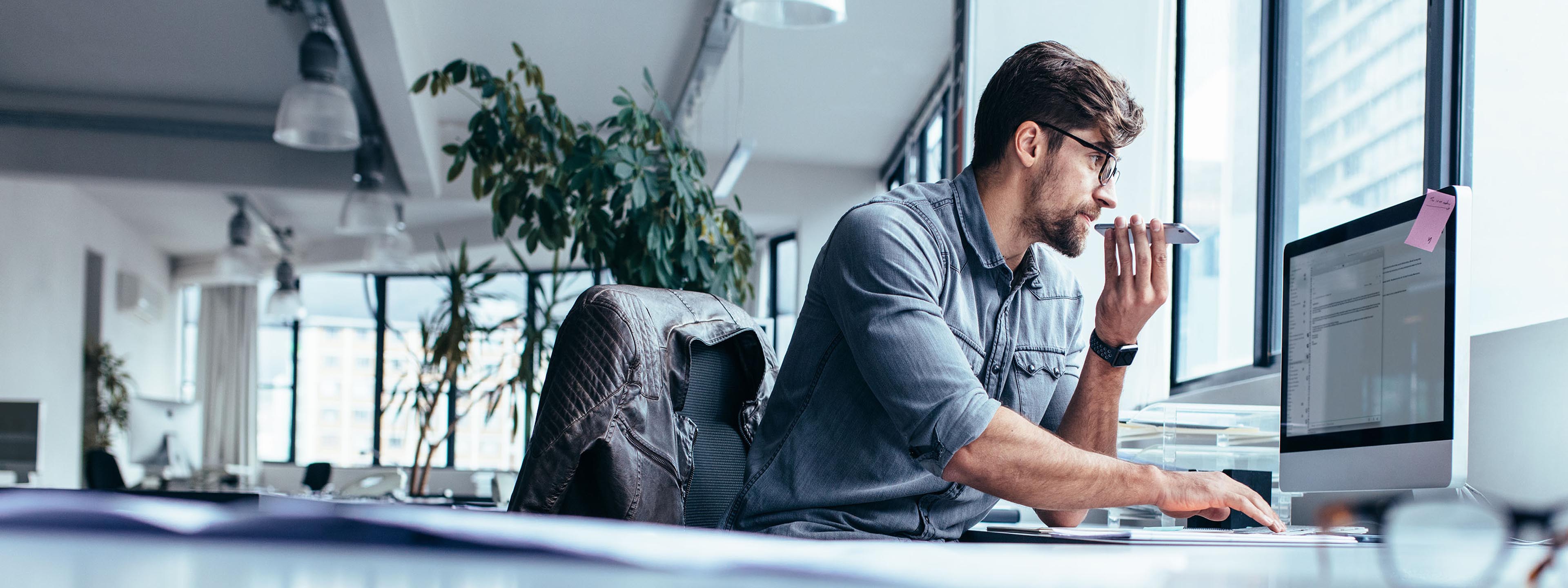 guy behind the computer in an open office space