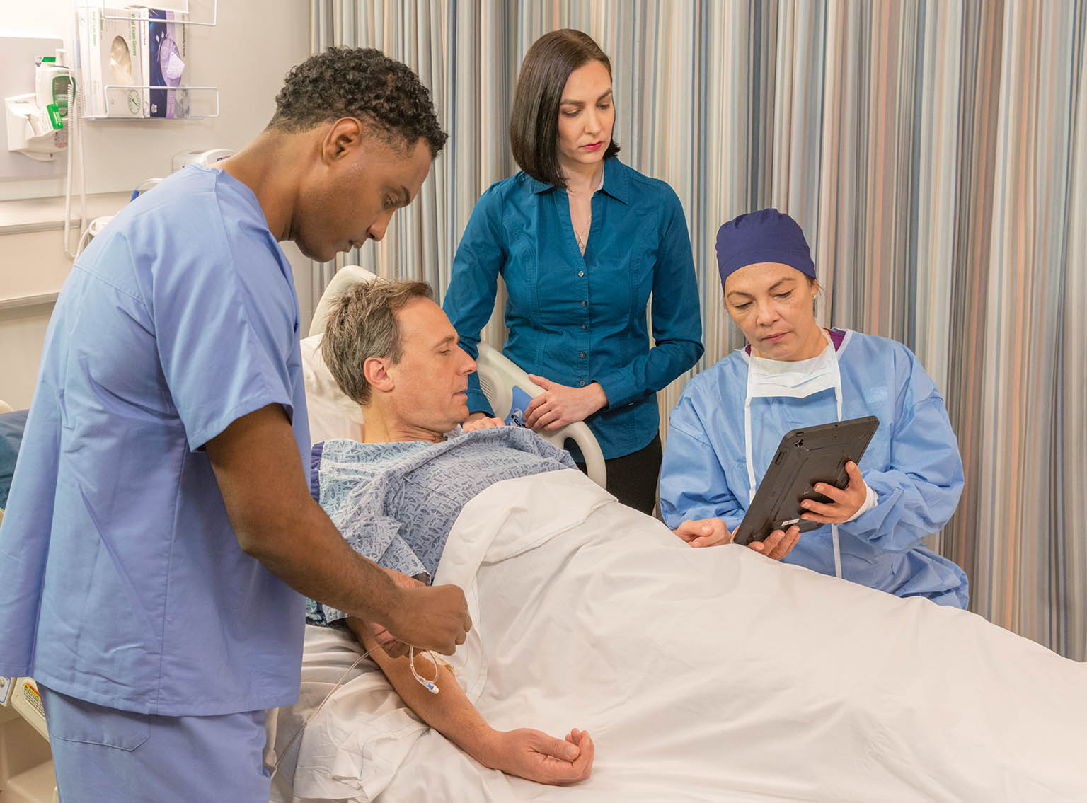 nurse and surgeon talking to male patient