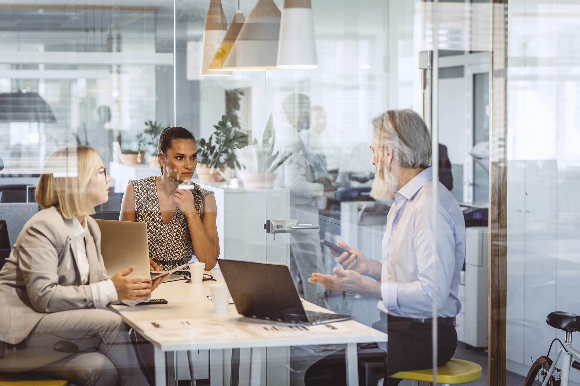 Business people discussing on a project in the see through conference room.