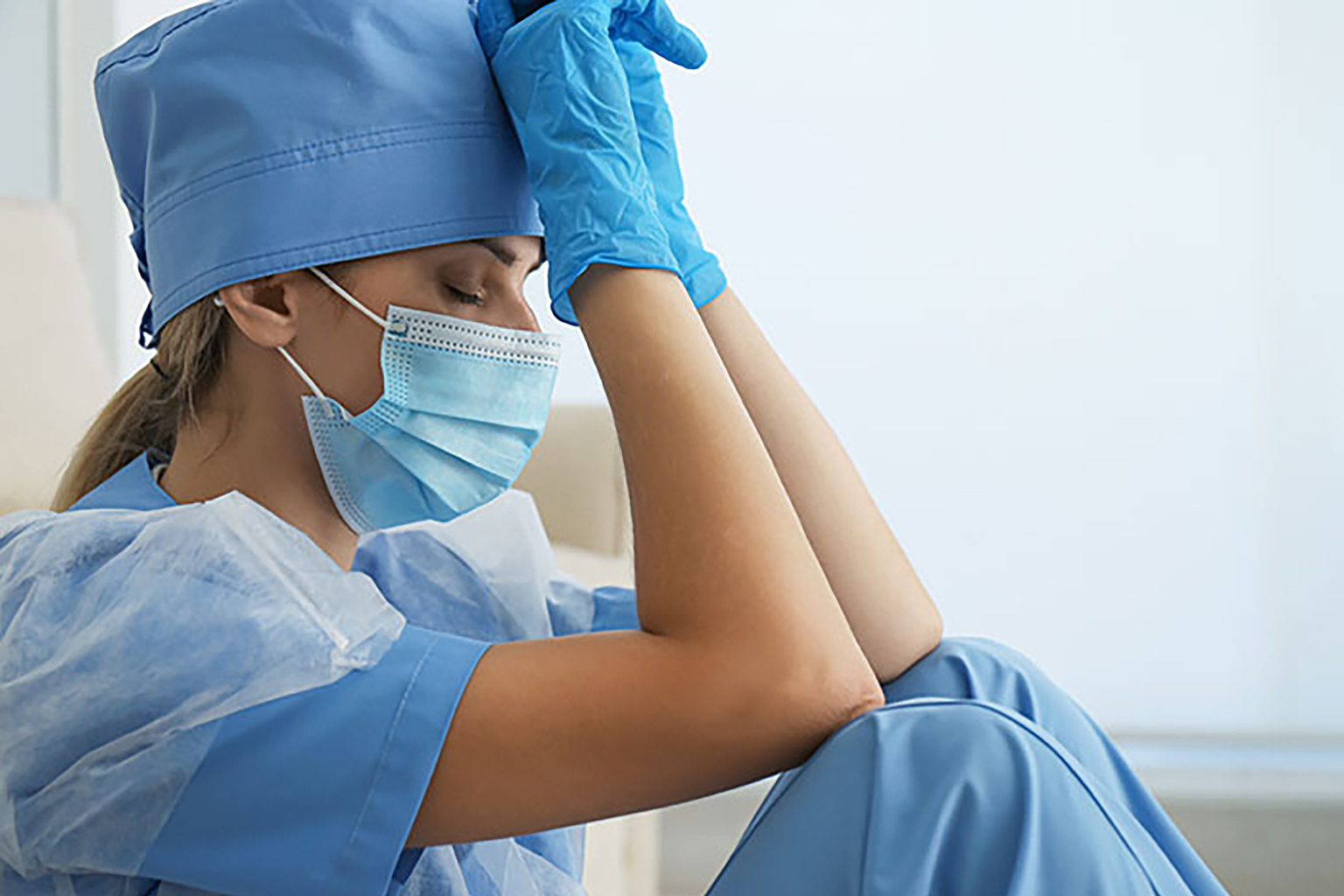 healthcare worker in scrubs looking stressed