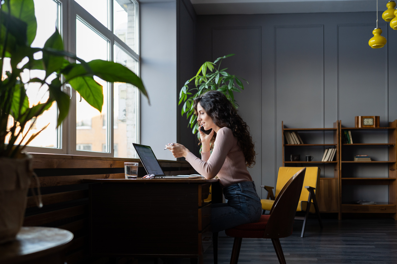 Woman on the phone looking at CCH AnswerConnect on her laptop