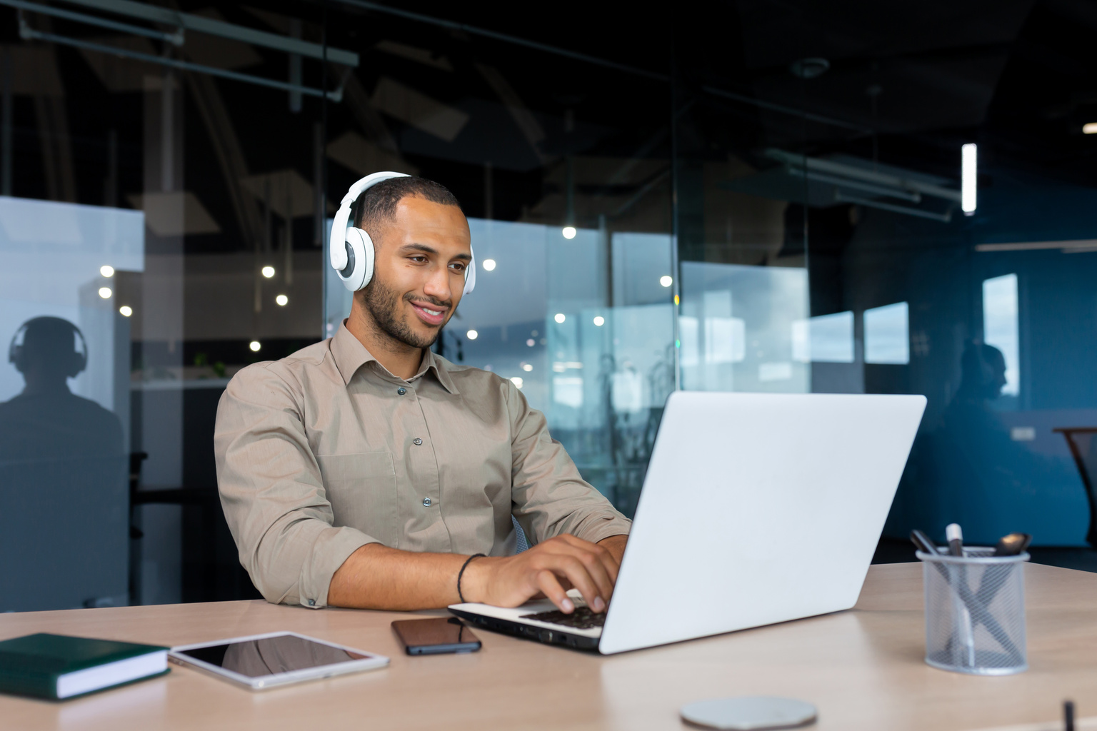 Man with headphones listening to audio podcasts at work