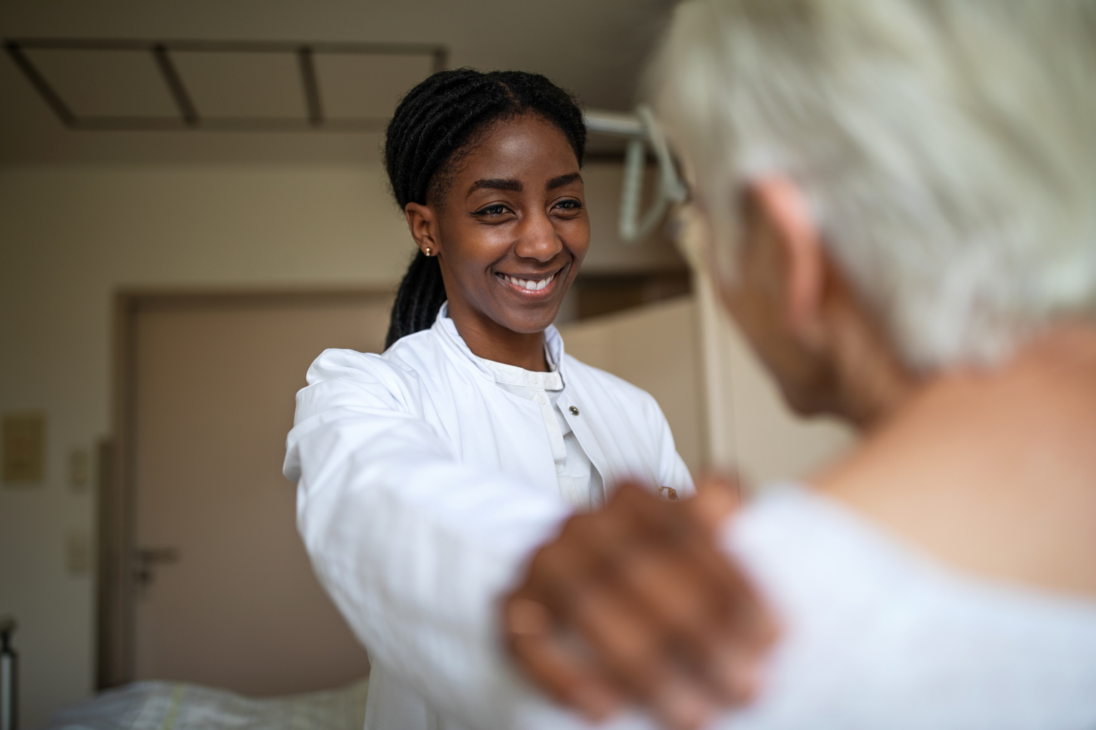 Doctor comforting her senior patient in the hospital room