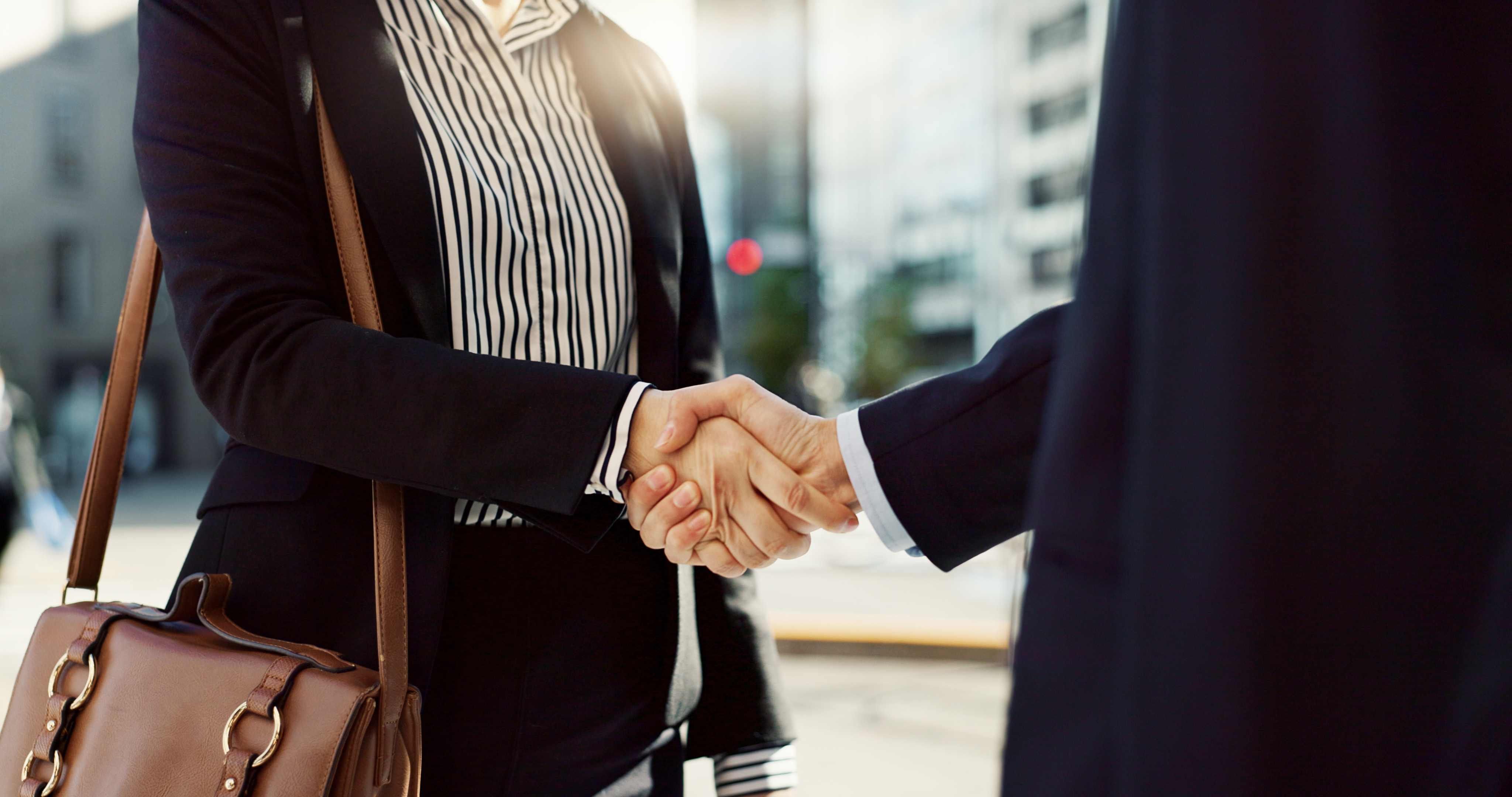 Woman and man shaking hands in a city