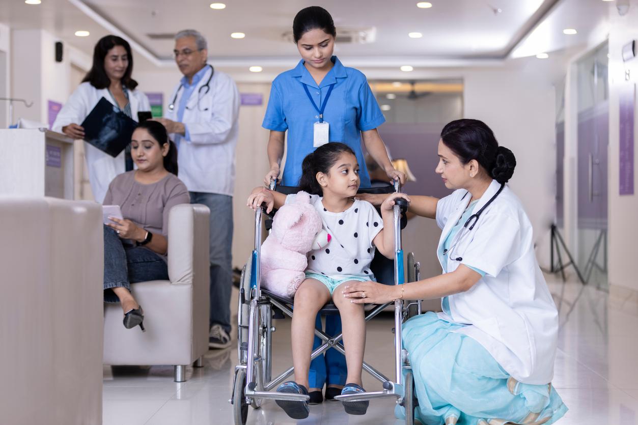 Concerned nurse and doctor care for pediatric patient in a wheel chair