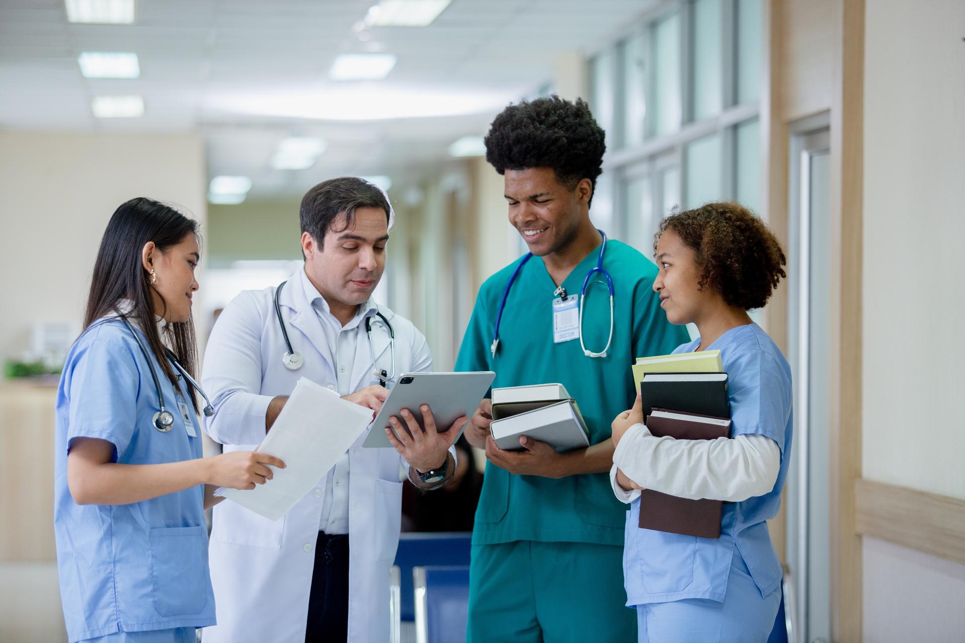 Health care professionals gathered at nurses station reviewing patient information