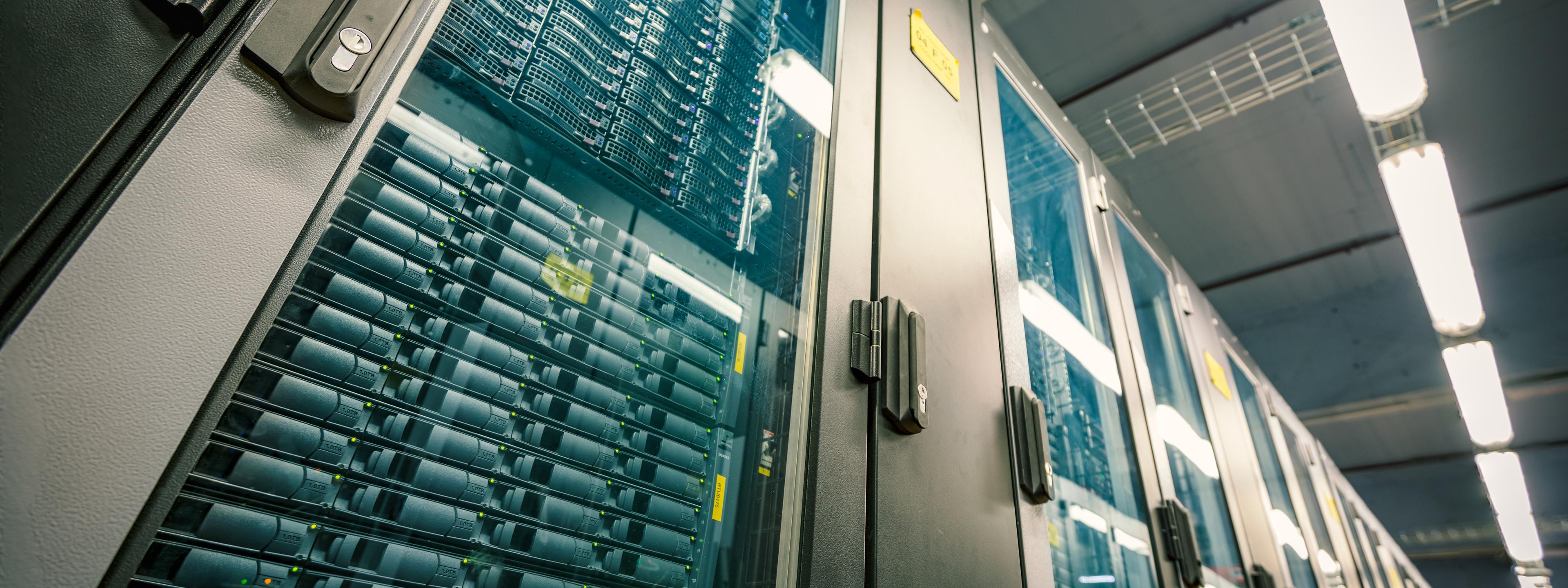 Abstract of modern high tech internet data center room with rows of racks with network and server hardware.