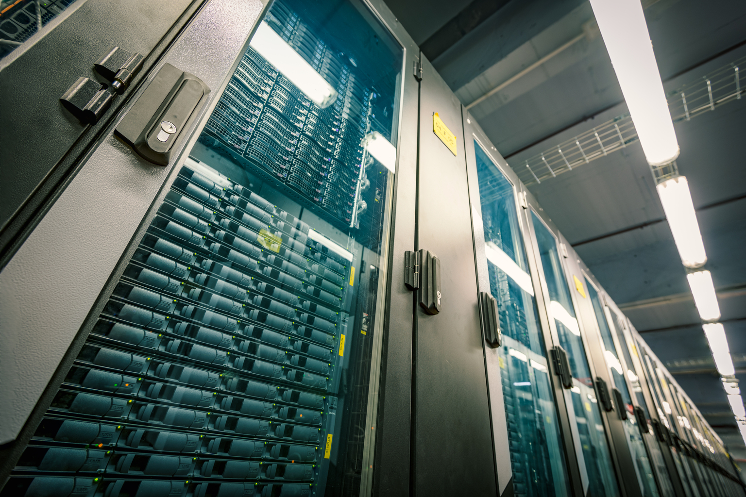 Abstract of modern high tech internet data center room with rows of racks with network and server hardware.