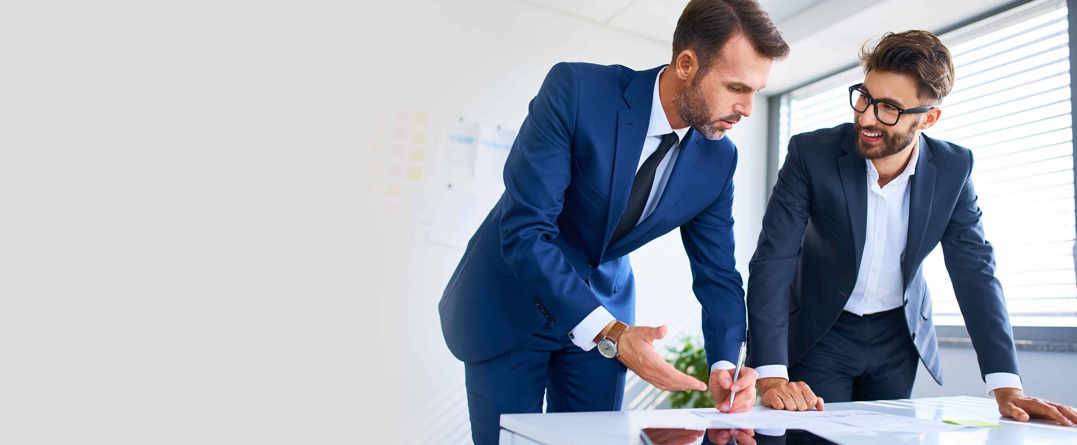 Two businessmen reviewing business documents in office