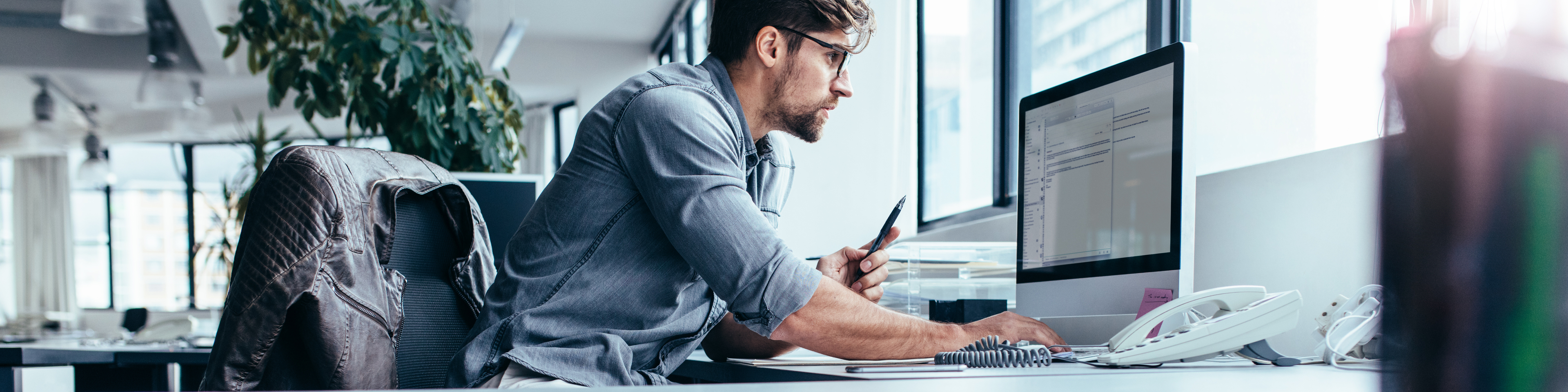 Young businessman in office working on computer AS183077832