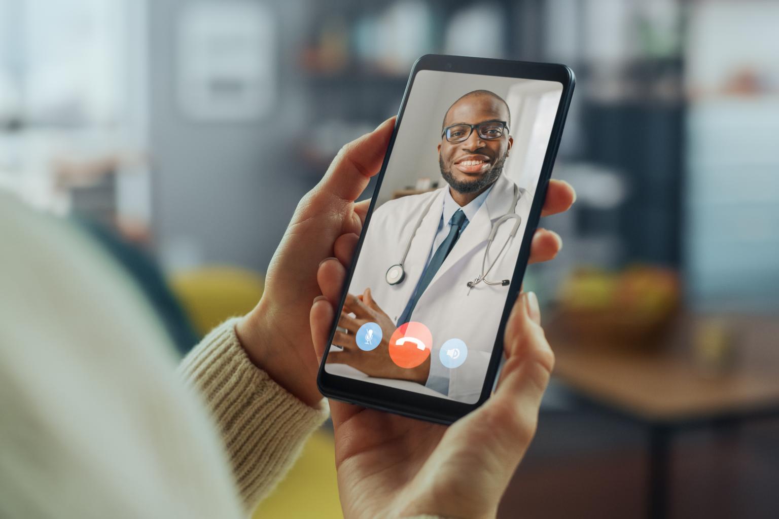 Portrait of a pair of hands holding a smartphone making a video call to a male doctor AS430811811