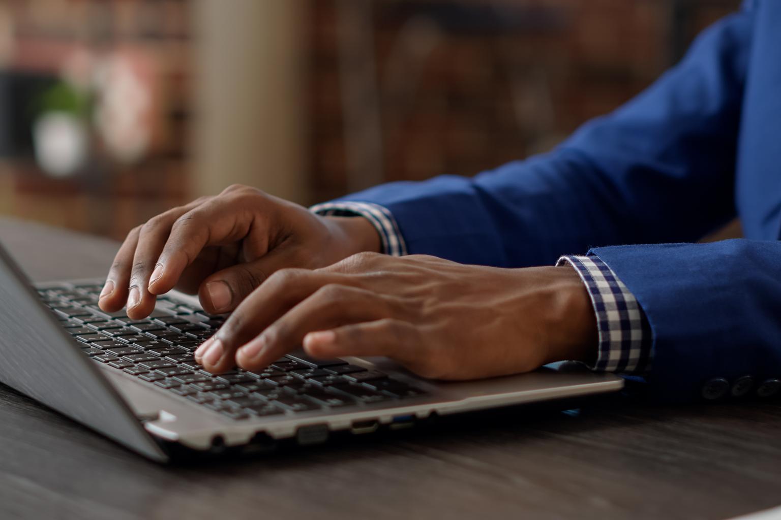 man in blue suit on laptop