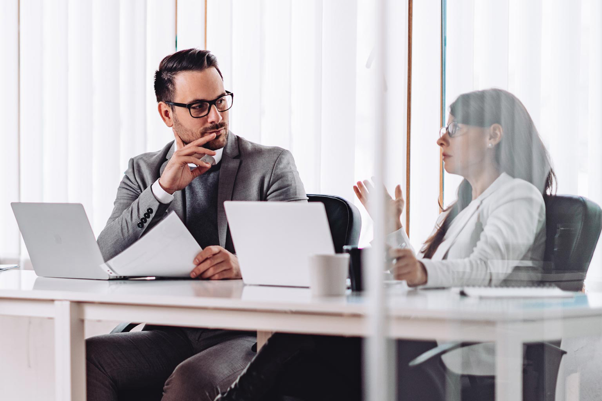 two people discussing in the office card image