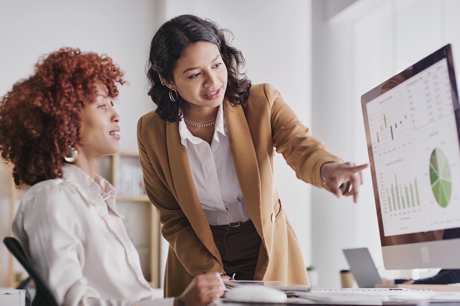 women employees looking at company data or analysis on pc