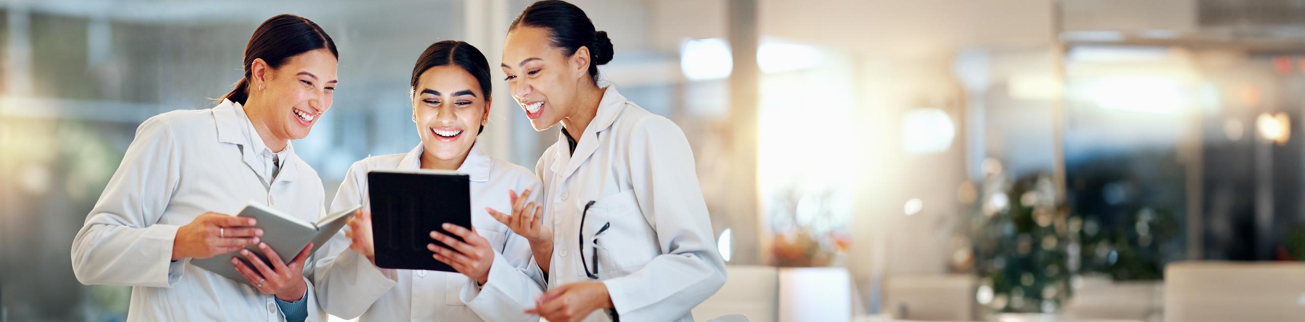 Female doctors collaborating and using a tablet to provide medical feedback and review results in a hospital setting