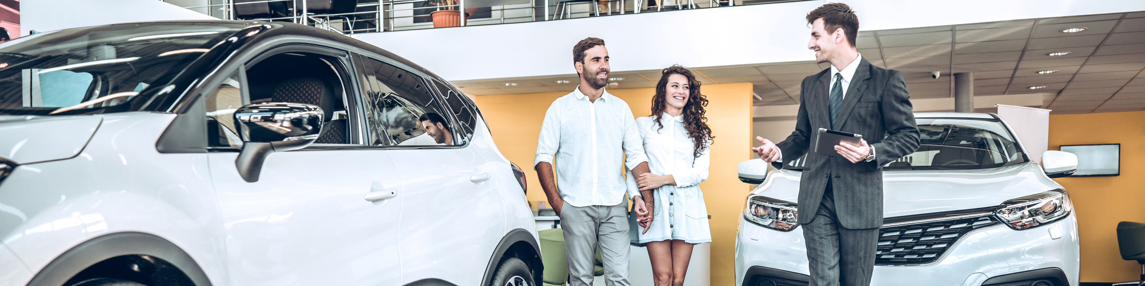 Sales manager helping young couple to choose a new car