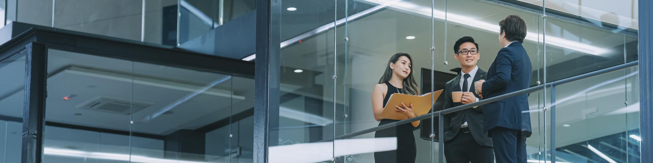 Chinese business person meeting working late at night in meeting room looking through window