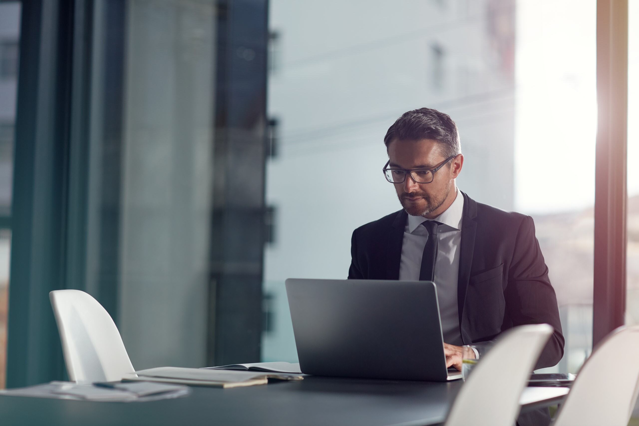 Businessman at laptop in meeting room